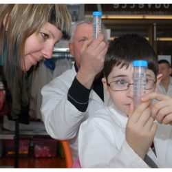 Sous le regard de Périne, Killian et son père Dominique observent des filaments de leur propre ADN, le 11 février 2012 à L’Eprouvette (le laboratoire public de l’Université de Lausanne). Le liquide dans l’éprouvette est un mélange de salive, de savon et d’eau salée. L’ajout d’alcool à 90 degrés permet d’extraire l’ADN par précipitation. L’agrégat blanchâtre est appelé « méduse ADN ». Photo Nicole Chuard.