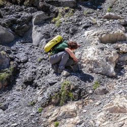 Adrien Pantet tente de localiser et décrire avec précision les contacts entre les différentes roches de la zone (ici entre une dolomie jaune à droite et un calcaire bréchique à gauche). Photo F. Ducrest © UNIL
