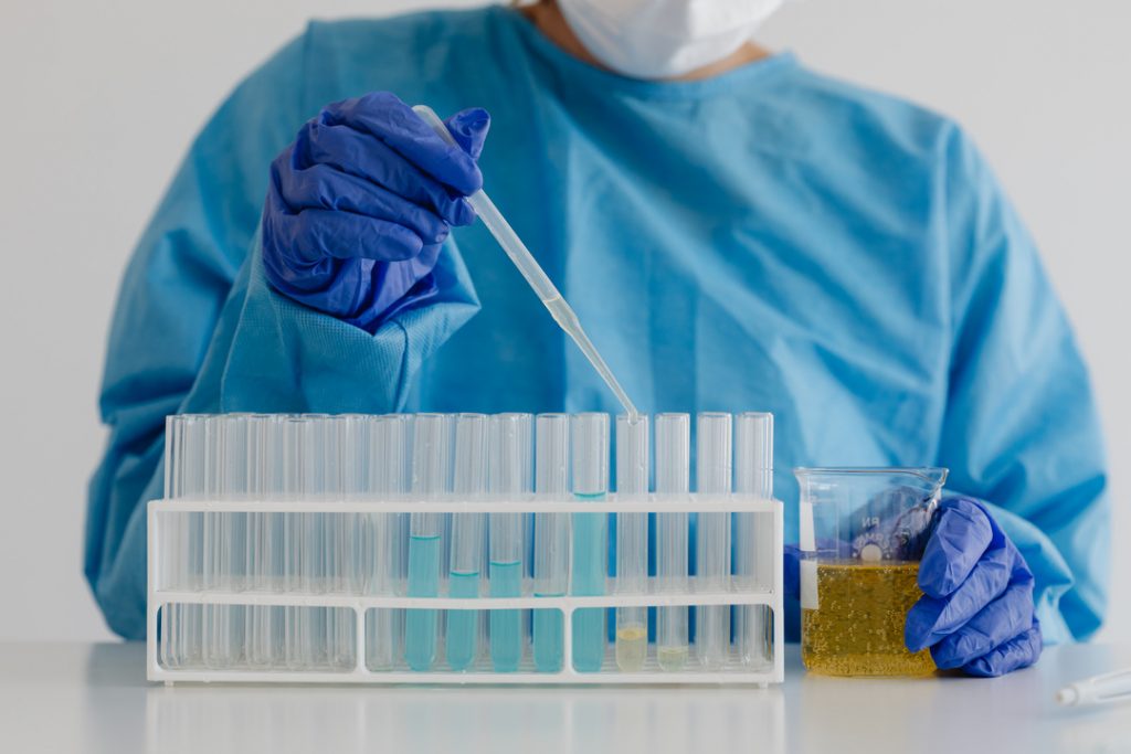kaboompics chemistry teacher pipetting into test tube rack 26315