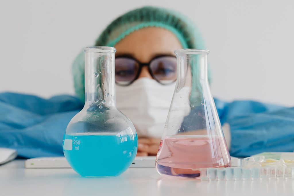 kaboompics female scientist framed by laboratory flasks 26255