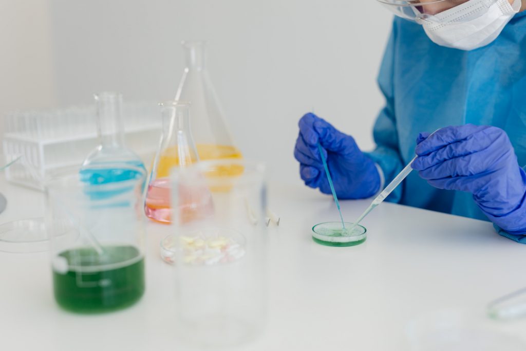 kaboompics gloved scientist pipetting a sample into a petri dish 26337