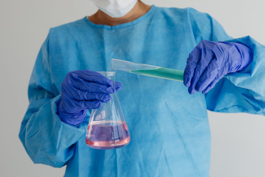kaboompics scientist measuring green solution into a conical flask 26353