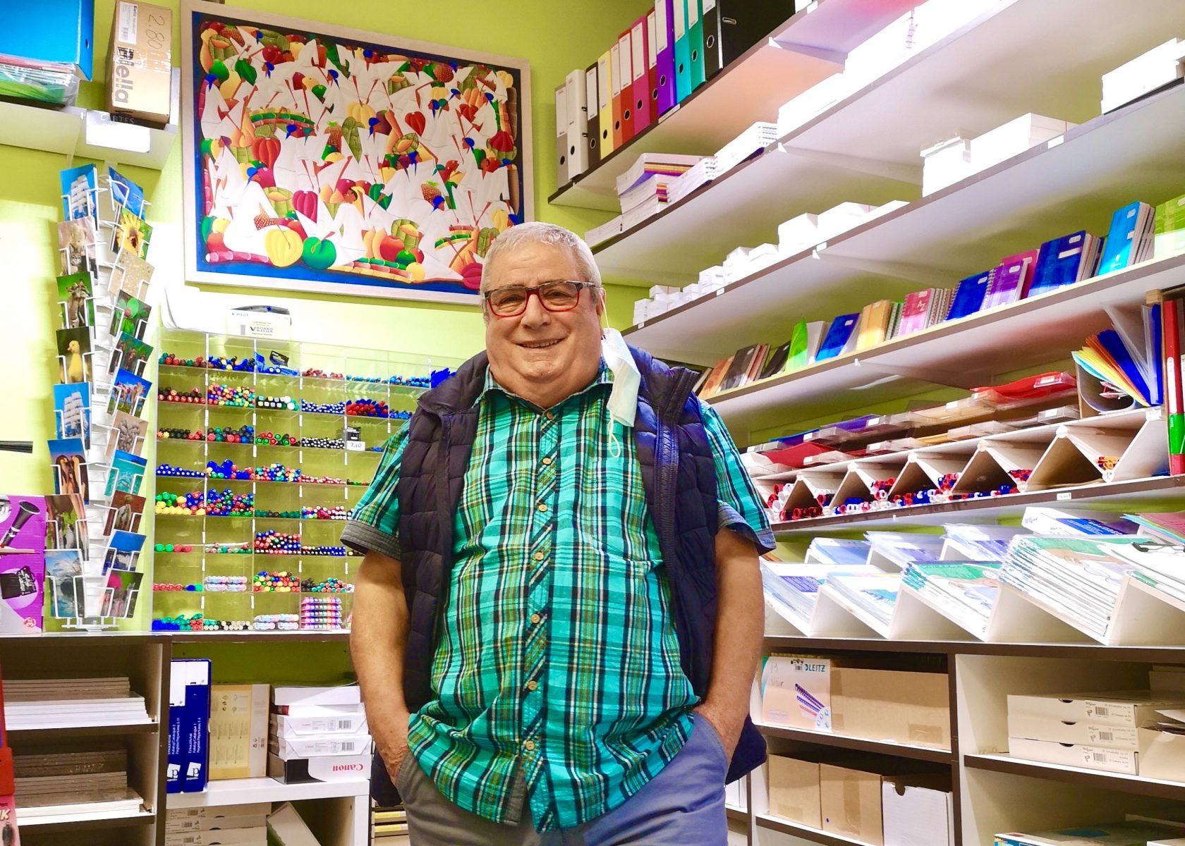 Enrico surrounded by his colorful products inside the stationary store