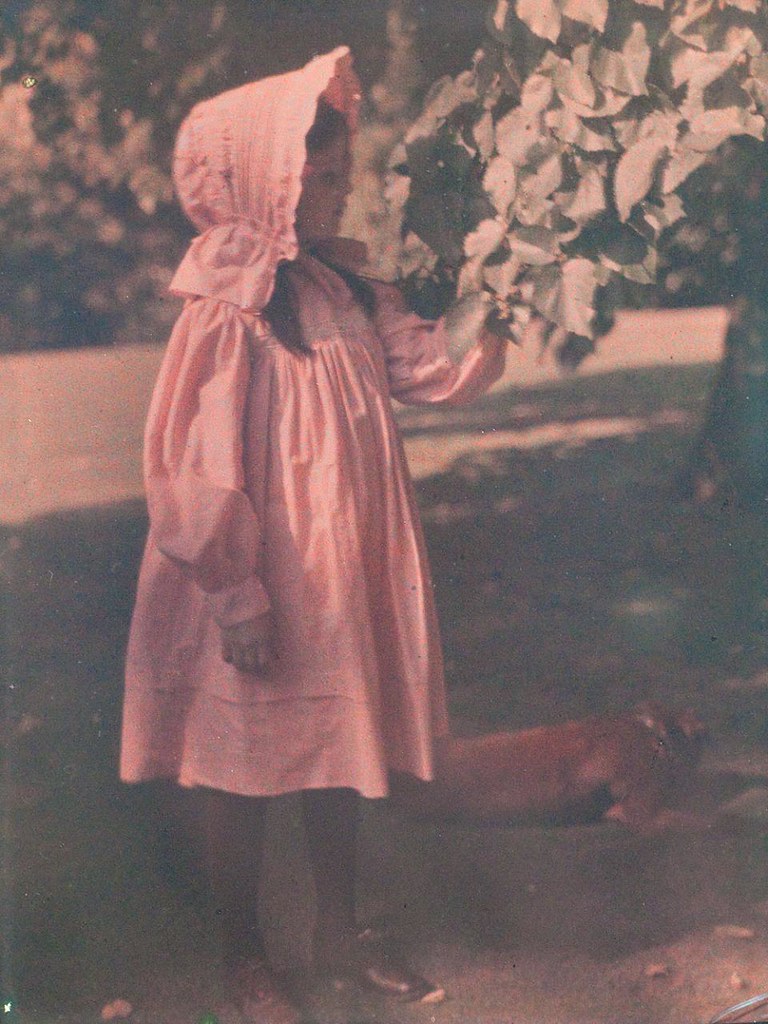 Gorgeous autochrome of young girl in bonnet, with dog