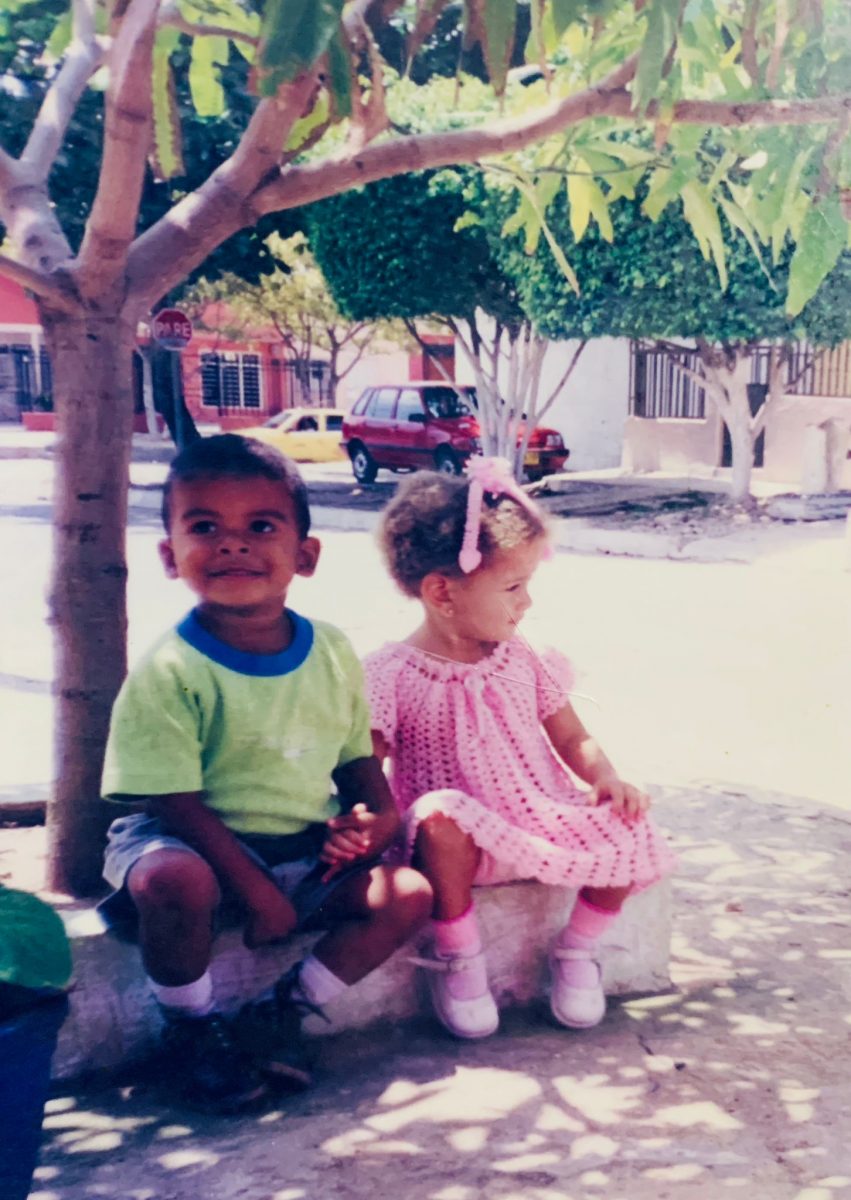 The author (right) with her cousin (left) sitting next to a mango tree