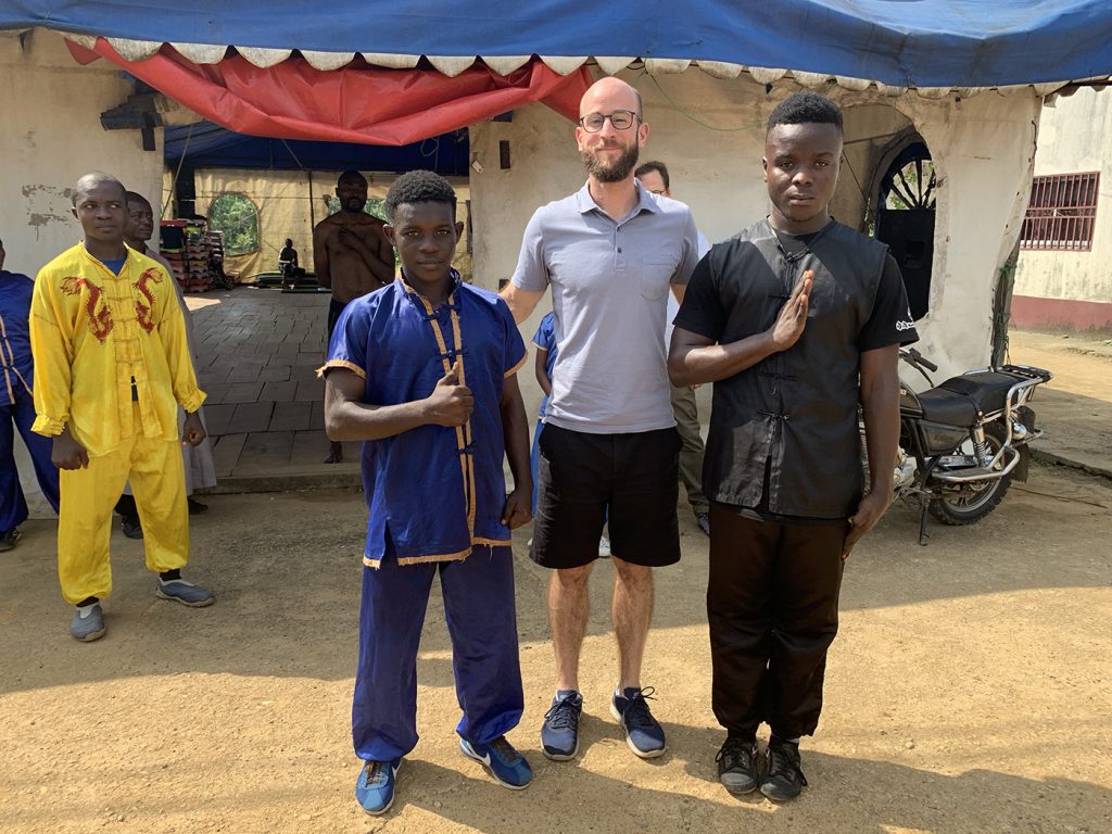 Alexandre Mathys posant avec des étudiants et le maître (derrière à gauche, avec la tenue grise) d’un club local de kung-fu à Douala, au Cameroun, en 2019. © DR